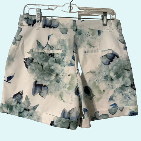 Floral shorts on a hanger against a white door