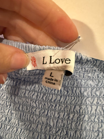 L Love brand label showing size L on pale blue smocked skirt