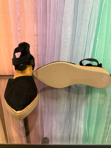 Black espadrille wedges showing the light-colored sole