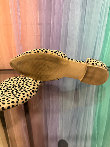 Spotted flats showing visible wear on the sole