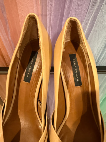 Interior of beige pumps showing Zara Woman labels and heel-edge wear