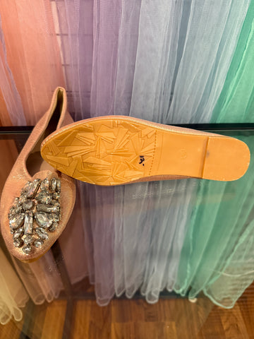 Blush jeweled flats with one shoe showing the sole